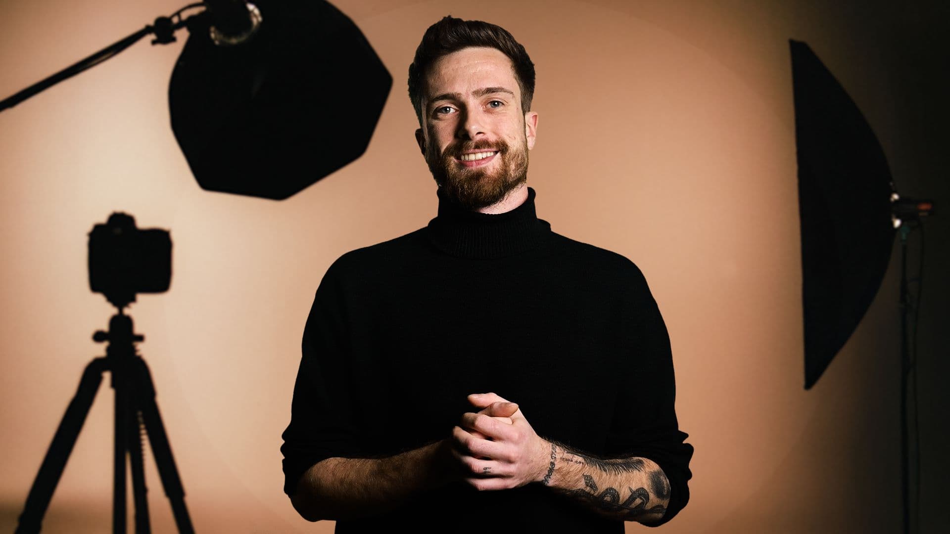 Eric Heitz im schwarzen Rollkragen im Studio, hinter ihm Kamera und Softboxen