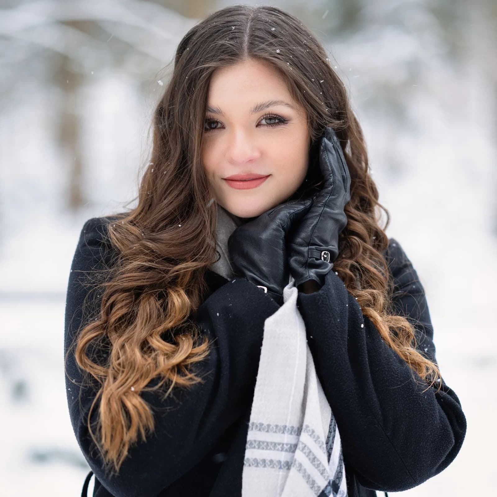 Winter portrait of a woman with curls, a scarf and leather gloves in the snow