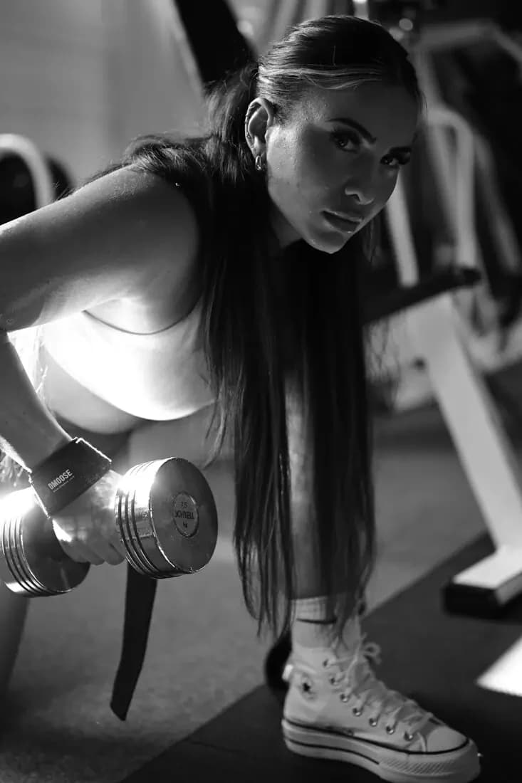 Black and white: woman with a dumbbell in the gym
